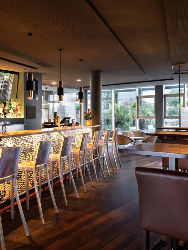 Bar moderno con luci calde e sedie alte di metallo