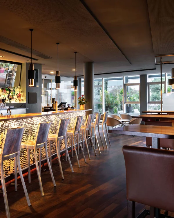 Bar moderno con luci calde e sedie alte di metallo
