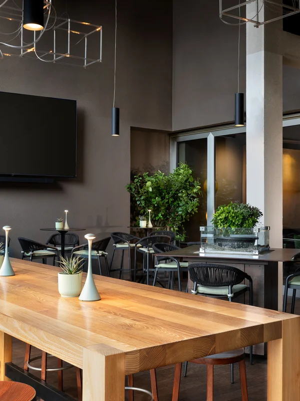 Innenraum eines modernen Restaurants mit Tischen, Stühlen und Wandfernseher