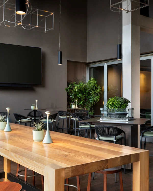 Interior of a modern restaurant with tables, chairs, and a wall-mounted TV