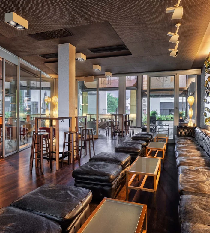 Interno moderno di un bar con sedute in pelle e parete decorativa luminosa